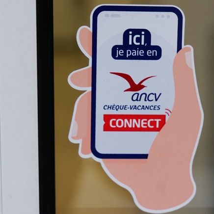 Un smartphone qui paye la location de ski en paiement Chèques-Vacance ANCV Connect